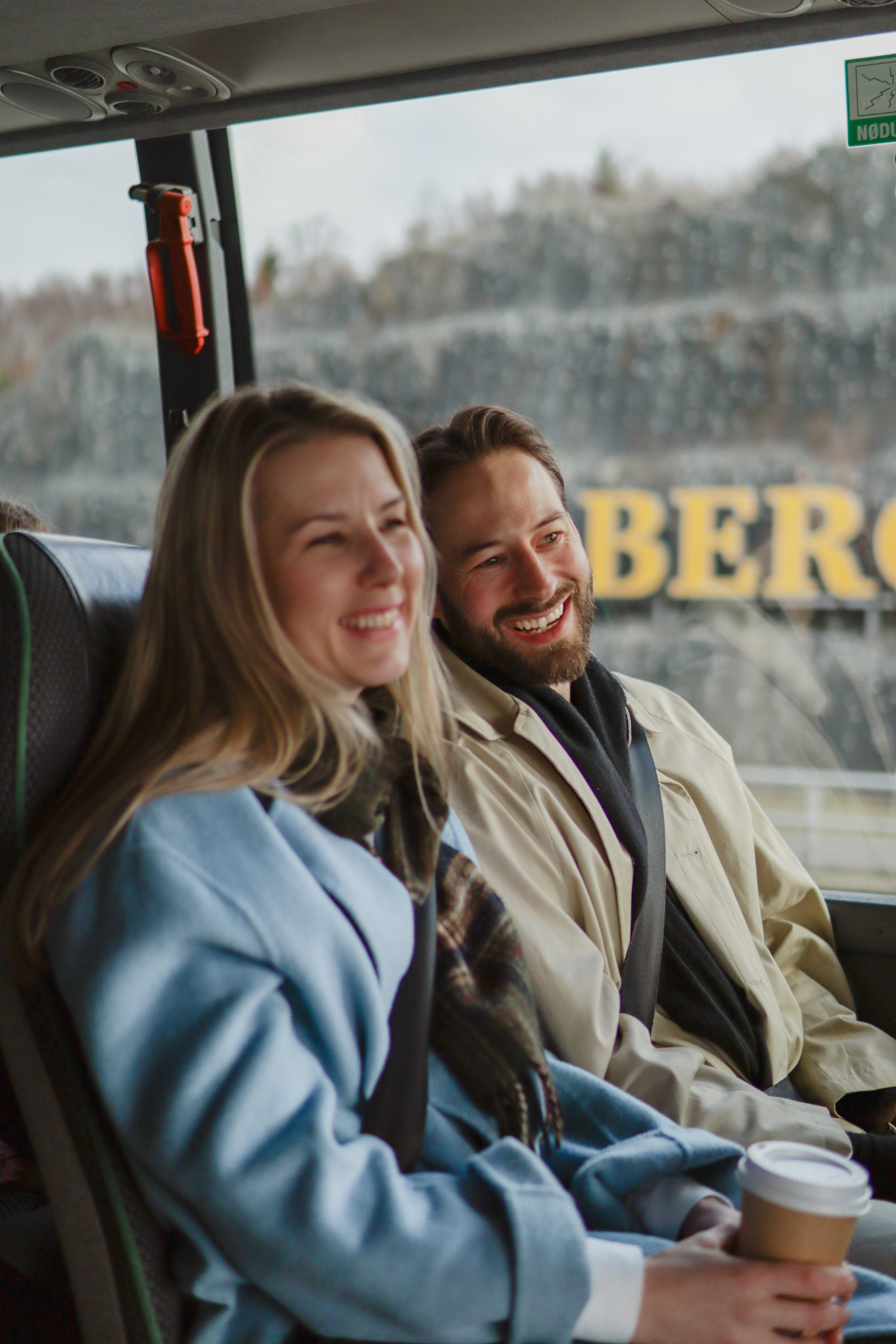 To personer som sitter på bussen og er glad